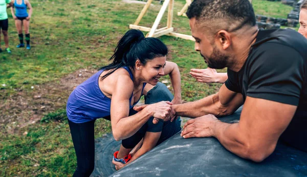 Femme dans un parcours d'obstacles escalader un tambour — Photo