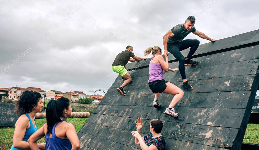 Participants in obstacle course climbing pyramid obstacle