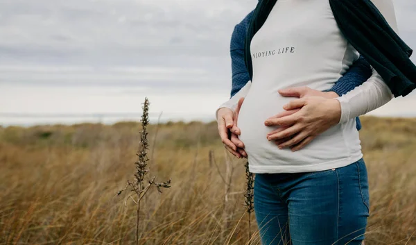 Zwangere met partner knuffelen en houden buik — Stockfoto