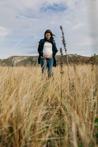 Gravid kvinde ser hendes mave - Stock-foto