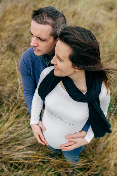 Těhotná s partnerem objímání a drží břicho — Stock fotografie