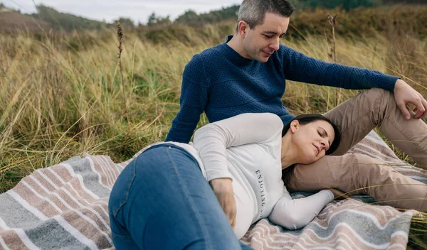 Mann sieht seine schwangere Frau im Gras liegen — Stockfoto