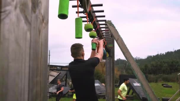 Carrera de obstáculos participante haciendo suspensión — Vídeos de Stock