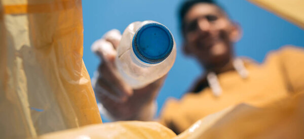 Young man throwing plastic bottles in the trash