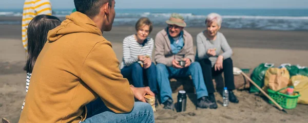 Volunteers resting after cleaning the beach — Stock Photo, Image