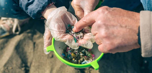 Colander with microplastics on the beach — Stock Photo, Image