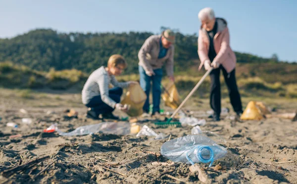 Voluntarios mayores limpiando la playa — Foto de Stock