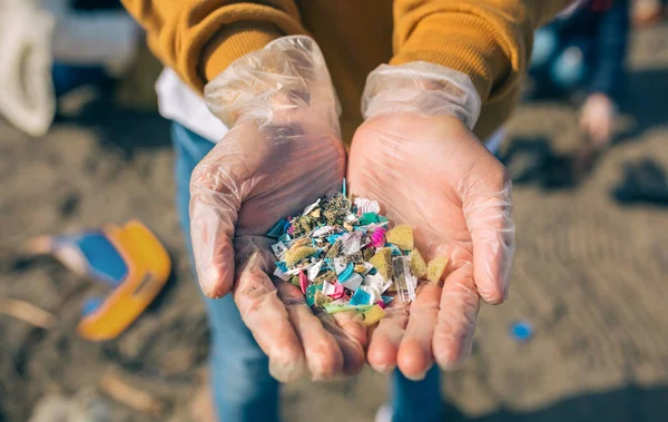ビーチでマイクロプラスチックと手 — ストック写真
