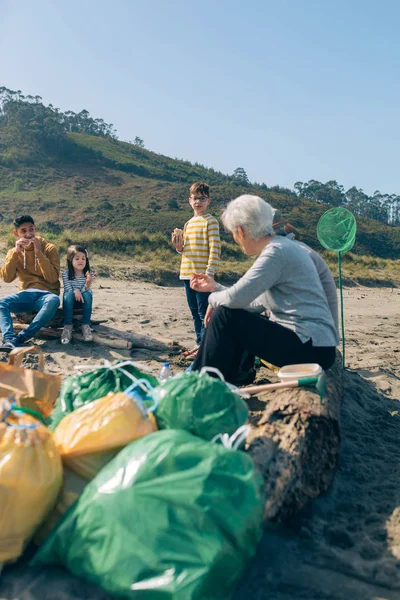 Vrijwilligers rusten na het schoonmaken van het strand — Stockfoto