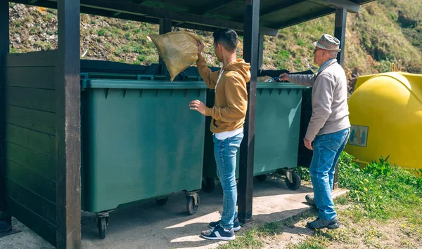 Men throwing garbage to container — Stock Photo, Image