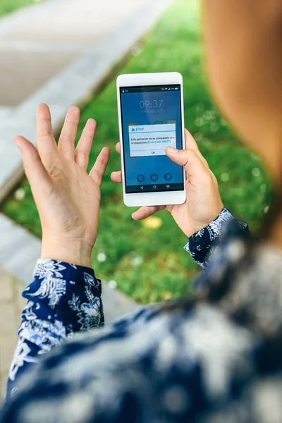 Mains tenant le téléphone avec le texte d'erreur de mise à jour à l'écran — Photo