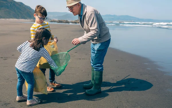 Vrijwilligers die vuilnis uit de zee halen — Stockfoto