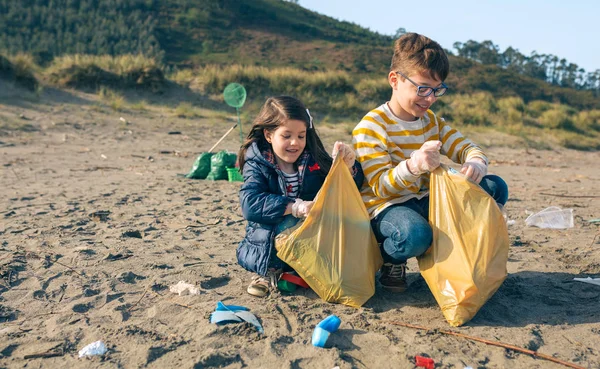 Kinderen vrijwilligers schoonmaken van het strand — Stockfoto