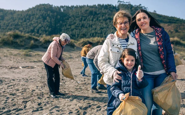 Vrouwelijke vrijwilligers die het strand schoonmaken — Stockfoto