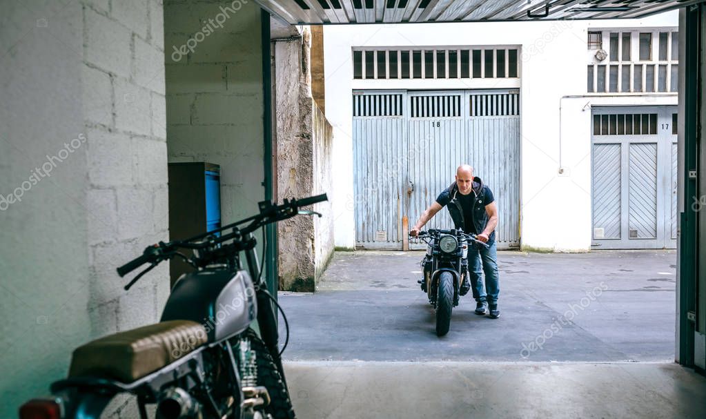 Biker taking motorbike to the garage