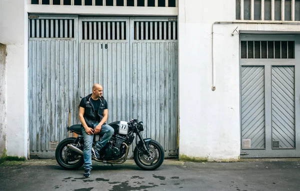 Biker posando com uma motocicleta — Fotografia de Stock