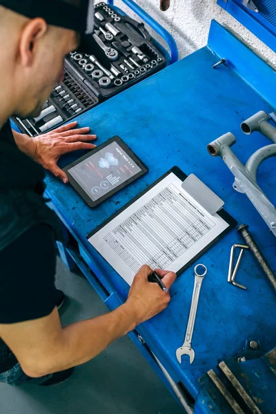 Μηχανικός χρησιμοποιώντας την εφαρμογή του τάμπλετ και λήψη σημειώσεων — Φωτογραφία Αρχείου