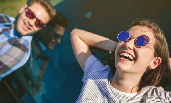 Young couple lying on the windshield — Stock Photo, Image