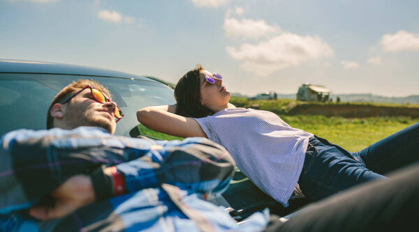 Young couple lying on the windshield