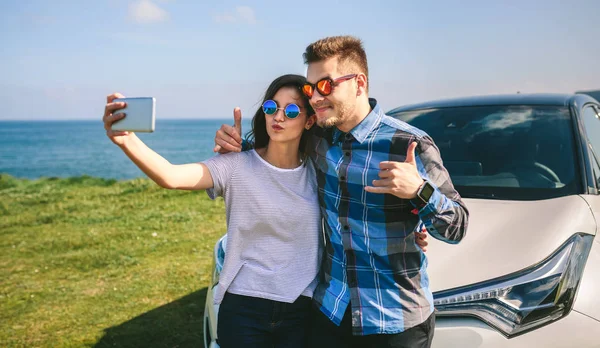 Jeune couple faisant un selfie sur la voiture — Photo