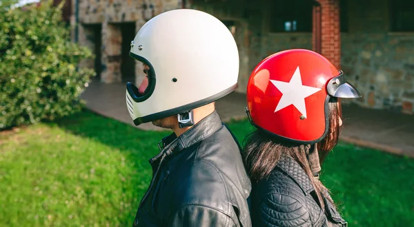 Casal posando com capacetes de motocicleta — Fotografia de Stock