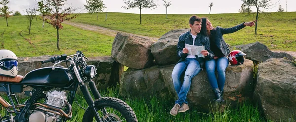 Couple assis regardant une carte avec moto — Photo