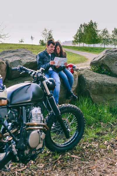 Пара сидящих на карте с мотоциклом — стоковое фото