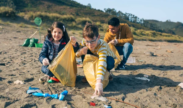 Jonge vrijwilligers die het strand schoonmaken — Stockfoto