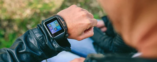 Unrecognizable young man looking at his smartwatch