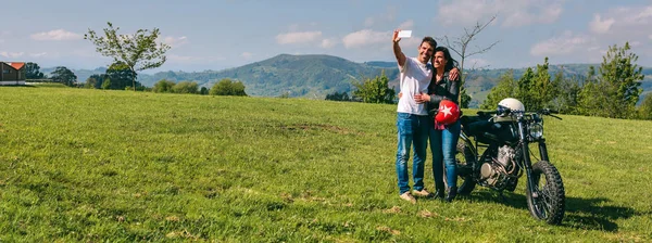 Pareja tomando una selfie con una motocicleta — Foto de Stock