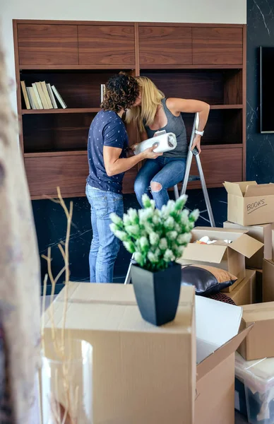 Par kyssar medan uppackning lådor — Stockfoto