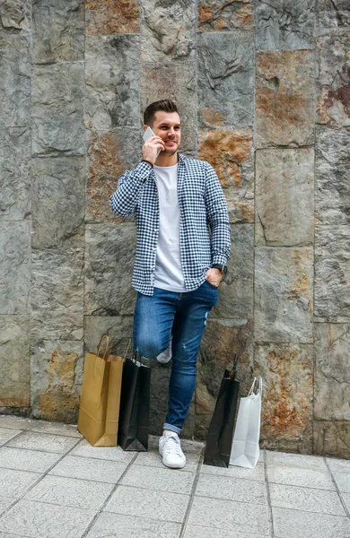 Young man with shopping bags and mobile — Stock Photo, Image