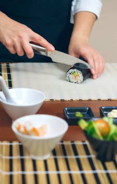 Kadın şef kesme Japon Suşi roll