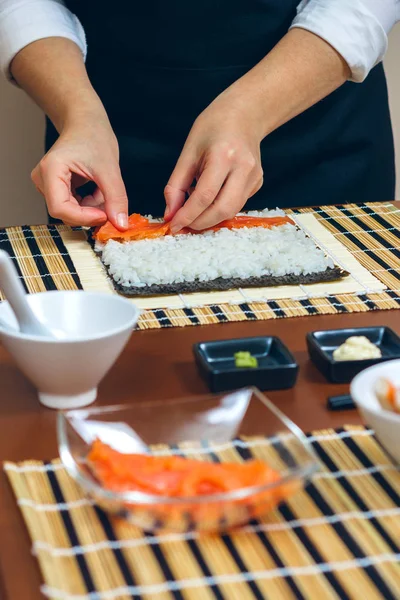 Chef-kok handen plaatsen ingrediënten op rijst — Stockfoto