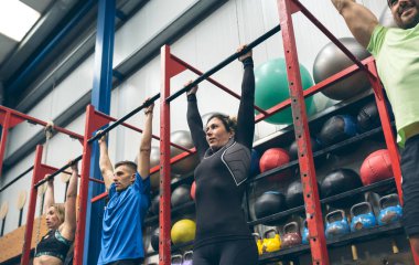 Sporcular barfiks çekmeye hazır.