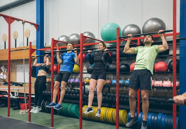 Atletas haciendo pull ups en el gimnasio —  Fotos de Stock