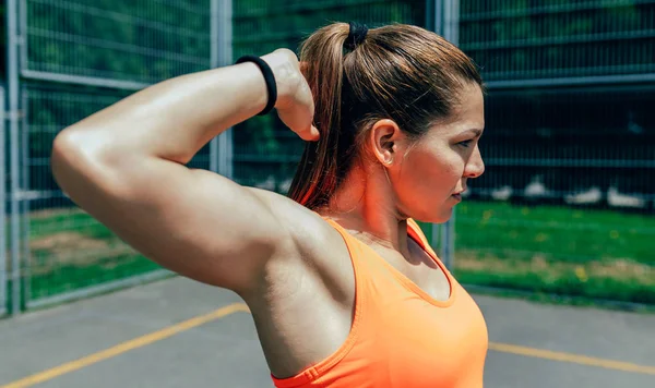 Deportiva haciendo estiramientos del brazo — Foto de Stock