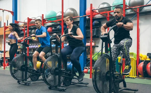 Atleti che fanno air bike indoor — Foto Stock