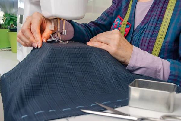 Seamstress mãos trabalhando em uma máquina de costura — Fotografia de Stock
