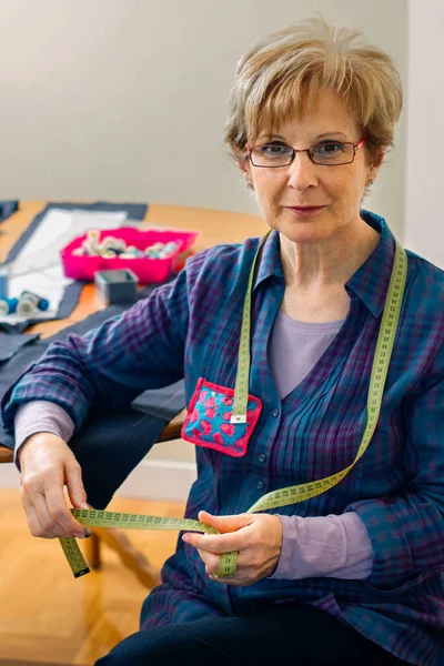 Costureira sênior posando com materiais de costura — Fotografia de Stock