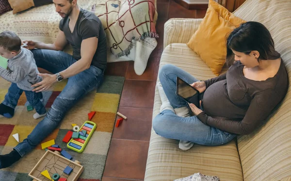 Padre giocare con suo figlio mentre la madre è alla ricerca di tablet — Foto Stock