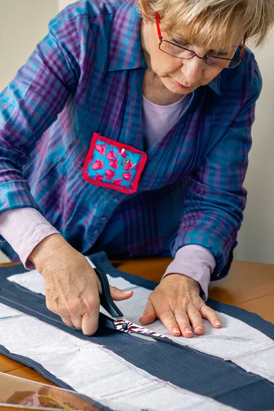 Dressmaker cortando um pano — Fotografia de Stock