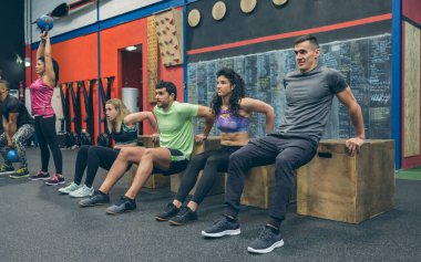 Kutu çömelme egzersizi yapan sporcular