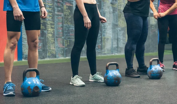 Unrecognizable group of athletes with kettlebells — Stock Photo, Image