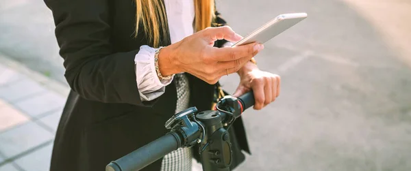 Unrecognizable businesswoman with e-scooter looking at cellphone — Stock Photo, Image