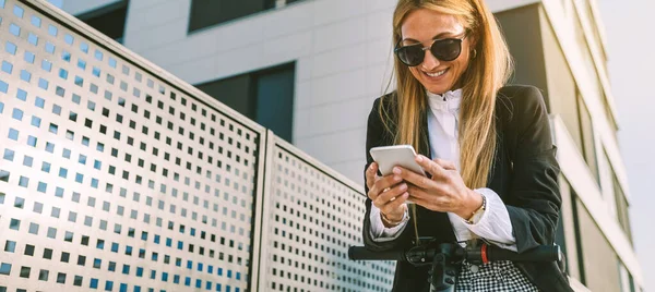 Mujer de negocios con scooter eléctrico mirando al móvil — Foto de Stock