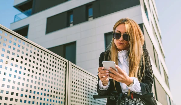 Mujer de negocios con scooter eléctrico mirando al móvil — Foto de Stock