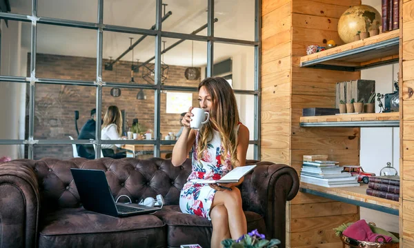 Бізнес-леді п'є каву і працює в коворкінгу — стокове фото