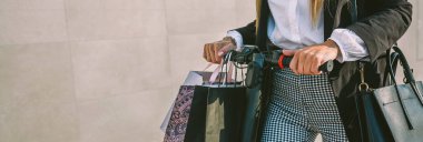 Elektrikli scooterlı alışveriş çantalı tanınmayan bir kadın.