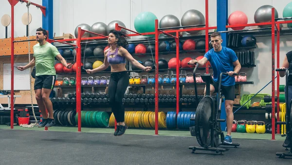 Atletas haciendo bicicleta de aire y saltar la cuerda —  Fotos de Stock